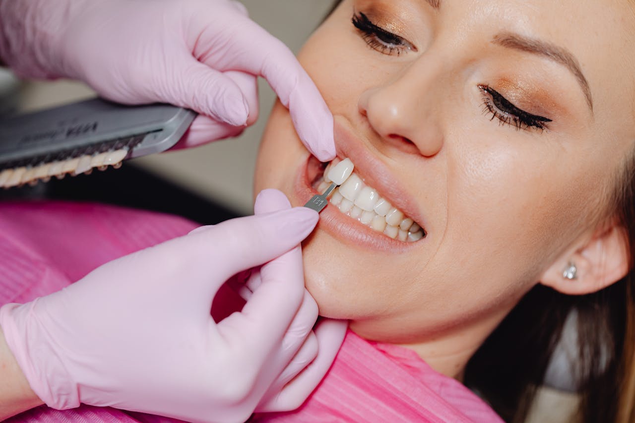 Services Close-up of a dental veneer being applied to a woman's teeth at a clinic.